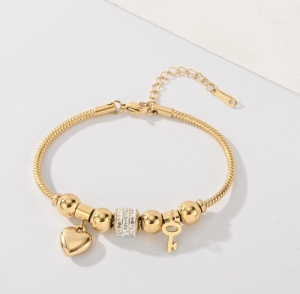 TTC10228 - Lắc tay titan phối charm tim khóa (màu vàng)