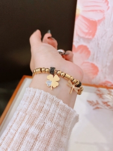 TTN10563 - Lắc tay titan dây rút phối charm cỏ 4 lá chuồn chuồn (màu vàng)